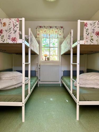 2 Etagenbetten in einem Zimmer mit Fenster in der Unterkunft Valla Vandrarhem in Linköping