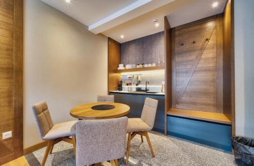 a small kitchen with a wooden table and chairs at Modern Mountain II Central in Kolašin