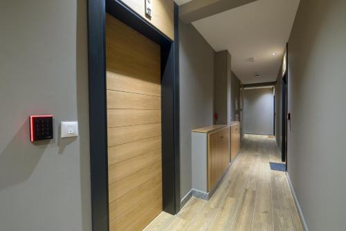 a hallway with a door leading into a hallway with wooden floors at Modern Mountain II Central in Kolašin