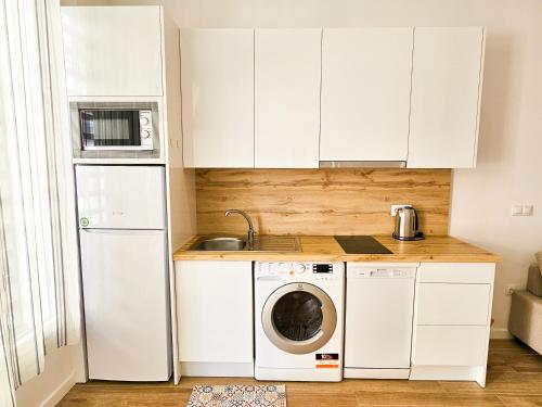 kuchnia z białymi szafkami i pralką w obiekcie Deluxe Valery 22 - Alojamientos La Torre w mieście Torre del Mar