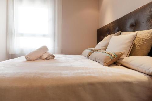 a large bed with two pillows on top of it at Espectacular piso cerca de la playa in Barcelona