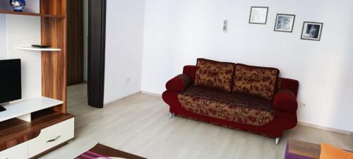 a living room with a red couch and a tv at 2х кімнатна квартира у Львові поряд з залізничним вокзалом in Lviv