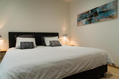 a bedroom with a large white bed with two pillows at Cheval Blanc - Holiday Rental in Aubel