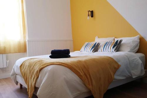 - une chambre avec un grand lit et un mur jaune dans l'établissement Escapade détente au cœur de Pamiers, à Pamiers