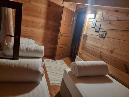 a room with two beds and a door and a room with wood at Ayder Rainbow Gokkusagi in Ayder Yaylasi