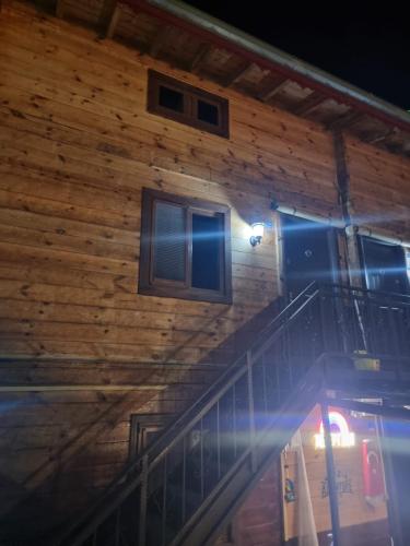 a wooden house with a staircase and windows at Ayder Rainbow Gokkusagi in Ayder Yaylasi