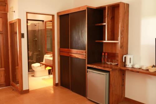 a kitchen with wooden cabinets and a bathroom at Boffo Resort in Loon
