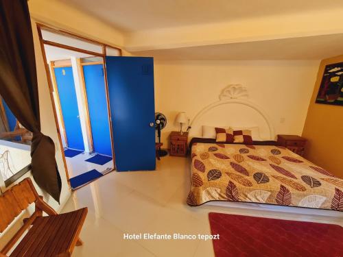 um quarto com uma cama e uma grande janela em HOSTAL DEL ELEFANTE em Tepoztlán
