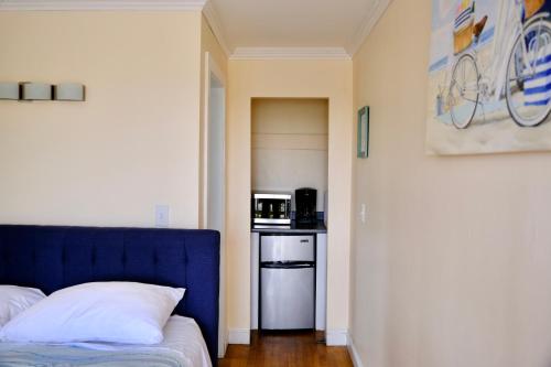 a bedroom with a blue bed and a microwave at The Landings Inn and Cottages at Old Orchard Beach in Old Orchard Beach