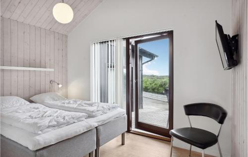 イェリングにあるBeautiful Home In Hjrring With 3 Bedrooms, Sauna And Wifiのベッドルーム1室(ベッド1台、椅子、窓付)