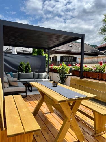 a patio with a picnic table and benches on a deck at FeWo Rosenstraße - Exklusive Ferienwohnung im Herzen von Tegernsee in Tegernsee