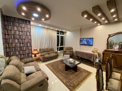 een grote woonkamer met een bank en een tv bij amazing apartment in the most luxurious area of ​​the Fifth Settlement in Caïro