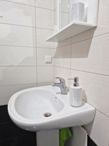 ein Badezimmer mit einem weißen Waschbecken und einem Spiegel in der Unterkunft V for the View in Patras
