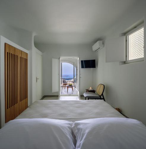 a bedroom with a bed and a view of the ocean at Aethria Villa in Imerovigli
