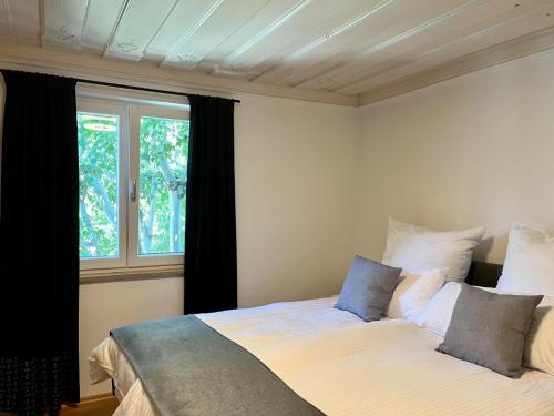 Schlafzimmer mit einem Bett und einem Fenster in der Unterkunft FeWo Rosenstraße - Exklusive Ferienwohnung im Herzen von Tegernsee in Tegernsee