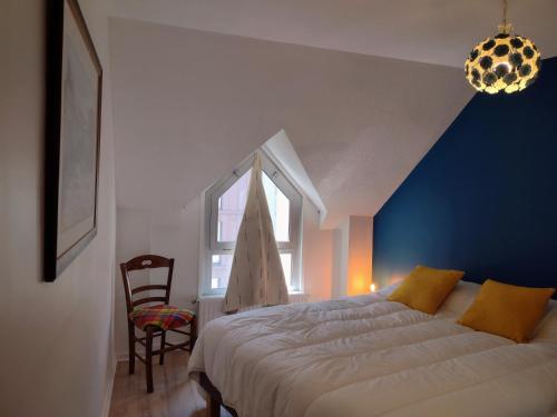 a bedroom with a bed and a blue wall at L'incontournable, centre ville parking WIFI in Vannes