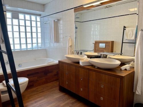 ein Badezimmer mit 3 Waschbecken, einer Badewanne und einem Tubermott in der Unterkunft FeWo Rosenstraße - Exklusive Ferienwohnung im Herzen von Tegernsee in Tegernsee