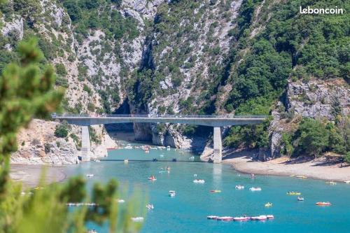 un pont sur une rivière avec des bateaux dans l'eau dans l'établissement CAMPING 3* ! PROGHE DES GORGES DU VERDON ET LAC DE STE CROIX 04500 ! TOUT EQUIPE ! CHAMPS DE LAVANDES ! CALME ! NBRES ACTIVITES ! RANDONNEES ! NAUTISME !, à Sainte-Croix-de-Verdon