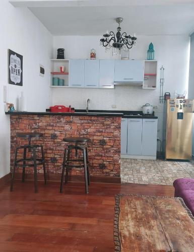 La Molina的住宿－Depa Excelente Vintage，一间厨房,内设一个柜台和两个凳子