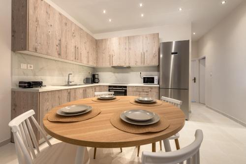 a kitchen with a wooden table and white chairs at Coastal Getaway: Roomy Beachside Apartment! in Nea Makri