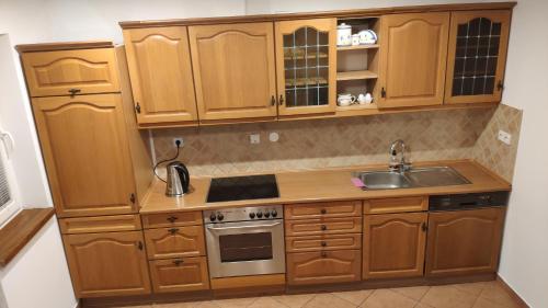 a kitchen with wooden cabinets and a sink at Ubytovanie u Grošíka in Oščadnica