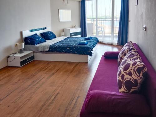 a bedroom with a bed and a couch at Apartament Midia in Aheloy