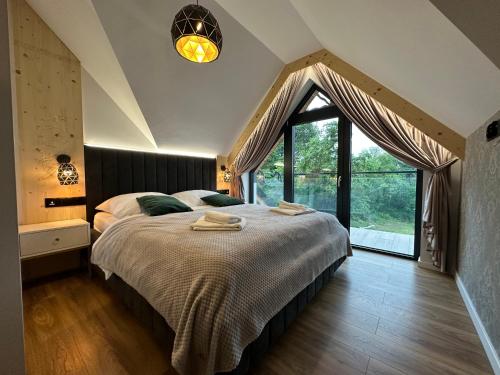 a bedroom with a large bed and a large window at Santa Angela Solina Resort & SPA in Solina