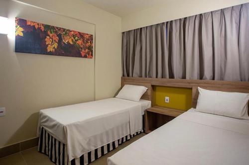 a hotel room with two beds and a window at Apto completo no Enjoy Solar das águas park resort in Olímpia