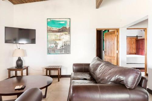 a living room with a leather couch and a table at Calivista Vineyard in Tunuyán