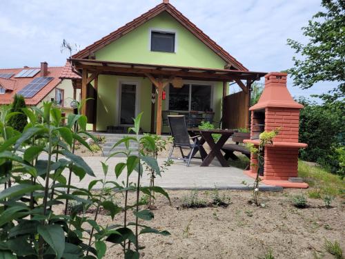 ein kleines Haus mit einer Terrasse und einem Kamin in der Unterkunft Pokoje Goscinne A.A.Malinowscy in Stegna