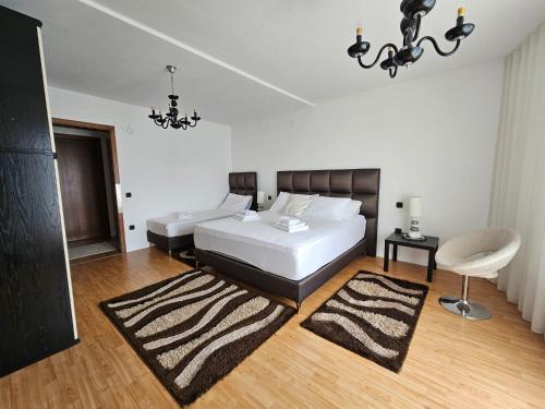 a bedroom with a large white bed and a chair at Residence Gordana 2 in Selce