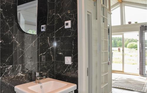uma casa de banho com um lavatório e um espelho em Nice Home In Hammar With Kitchen em Gunnarskär