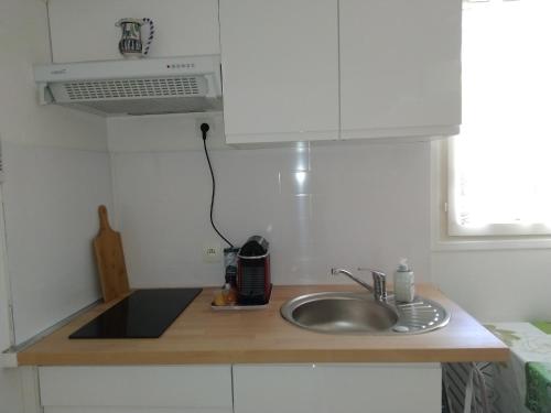 un comptoir de cuisine avec un évier et un micro-ondes dans l'établissement Studio neuf climatisé proche d'Agde, à Bessan