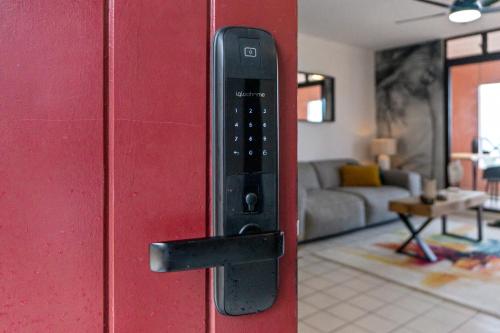 um controlo remoto numa porta vermelha numa sala de estar em Duplex standing et confort - Baby ready - 2 minutes de la plage Anse Mitan em Les Trois-Îlets
