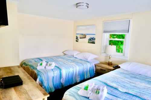 a room with two beds and a window at The Landings Inn and Cottages at Old Orchard Beach in Old Orchard Beach