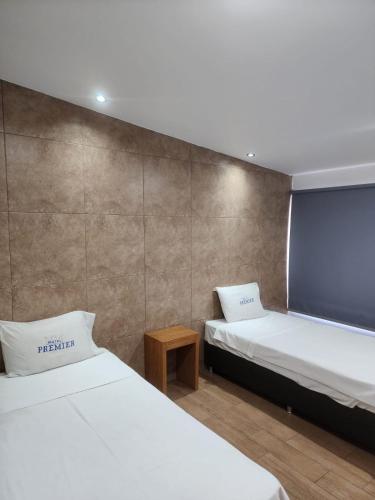 a bedroom with two beds and a wall at MOTEL PREMIER in Guadalajara