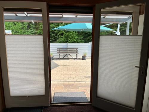 a sliding glass door with an open patio with an umbrella at Tiny Haus Dornbirn in Dornbirn