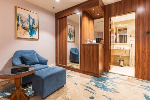 ein Wohnzimmer mit einem blauen Stuhl und einem Tisch in der Unterkunft فندق رويال دايموند الطائف in Ta'if