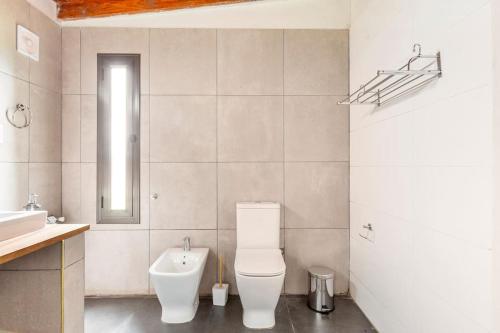 a white bathroom with a toilet and a sink at Calivista Vineyard in Tunuyán