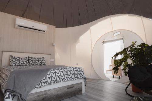 a bedroom with a bed and a large window at Fuente del Lobo Glamping & Bungalows - Adults Only in Pinos Genil