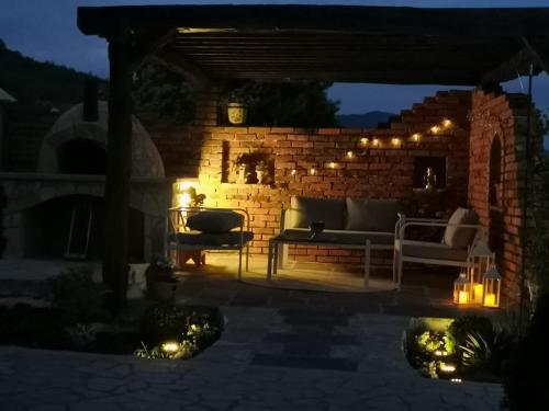 a patio with a couch and a brick wall with lights at Villa Emili in Posušje