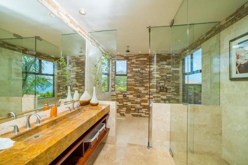 baño con 2 lavabos y ducha de cristal en AP-9A Casa Arena Blanca, en Ocotal