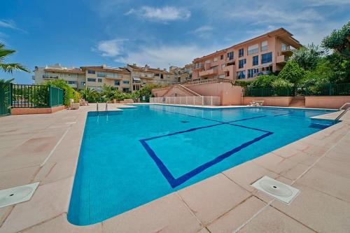 une grande piscine bleue avec des bâtiments en arrière-plan dans l'établissement Sunrise -Swimming-pool-Saint-Tropez center-parking, à Saint-Tropez