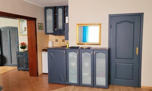 a kitchen with blue cabinets and a blue door at Apartament Brzoza Bydgoska in Brzoza