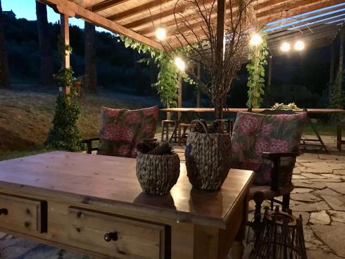 a wooden table with two vases on top of it at Bed&Breakfast La Madonnina in Marlia