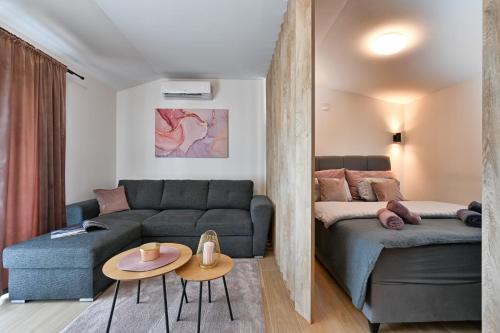 a living room with a couch and a bed at Tonka studio apartman in Križevci