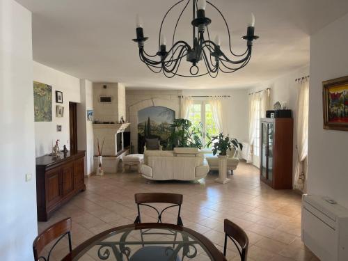 - un salon avec un canapé et un lustre dans l'établissement Les belles vacances, à La Cadière-dʼAzur