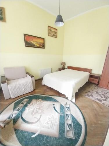 een slaapkamer met een wit bed en een tapijt bij 1ком апартаменты,парковка,улХорватская in Lviv