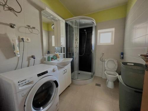 a bathroom with a washing machine and a sink at House for rest Ruda in Grab