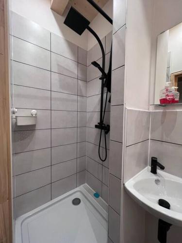 une salle de bain blanche avec un lavabo et une douche dans l'établissement Chalet Des Legendes, à La Combe